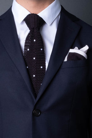 Black knitted pocket square with white frame. Made of silk in Italy paired with Matching tie.